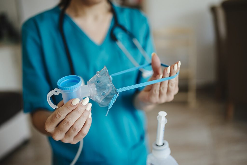 Healthcare professional demonstrates inhalation device in a medical setting undefined.jpg